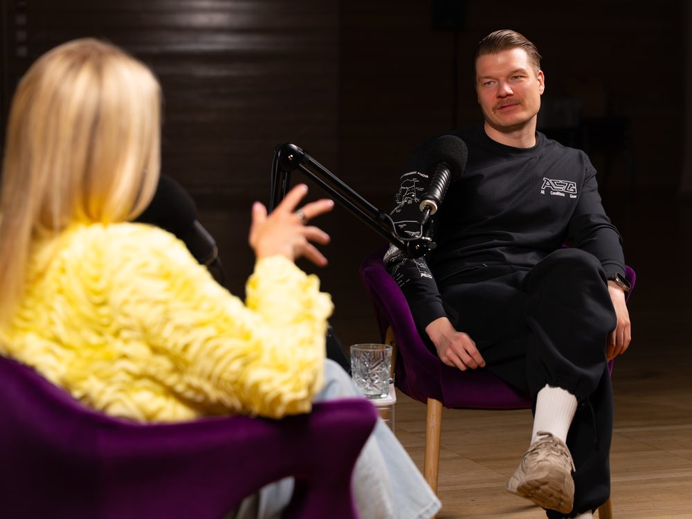 Joonas Kylliäinen podcast-keskustelussa studiossa, edessä toinen keskustelija.